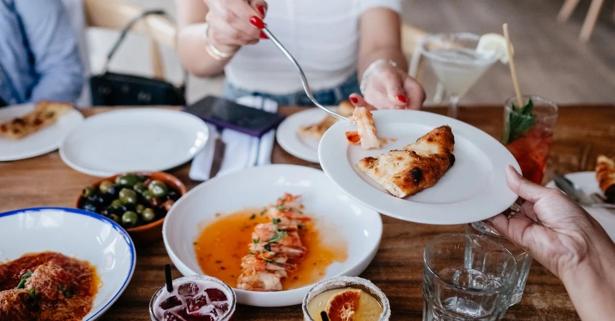 Des amis profitent d'un repas décontracté en partageant divers plats et boissons dans un restaurant.