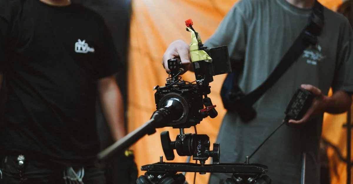 Membres de l'équipe utilisant un équipement de caméra avancé sur le plateau pour un tournage professionnel.