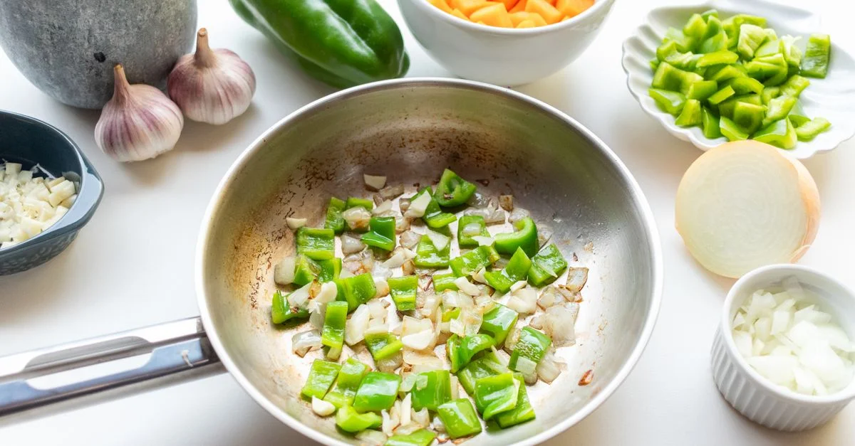 Une image appétissante de poivrons verts et d'oignons sautés, entourés de légumes frais et d'épices.